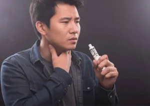 seseorang sedang mengalami burn taste vape dengan sensasi terbakar di tenggorokan dan mencari cara mengatasi burn taste vape